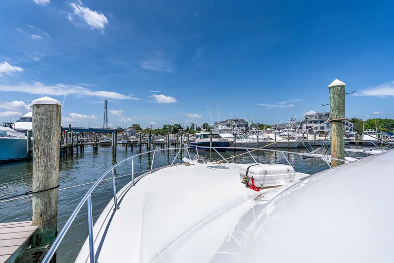 Slide: The Image of A boat is docked in a busy marina with clear skies and many other boats. - 46