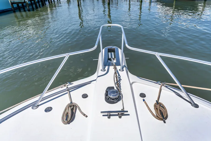 Slide: The Image of Bow of a boat with anchor windlass and ropes, resting on calm water. - 47