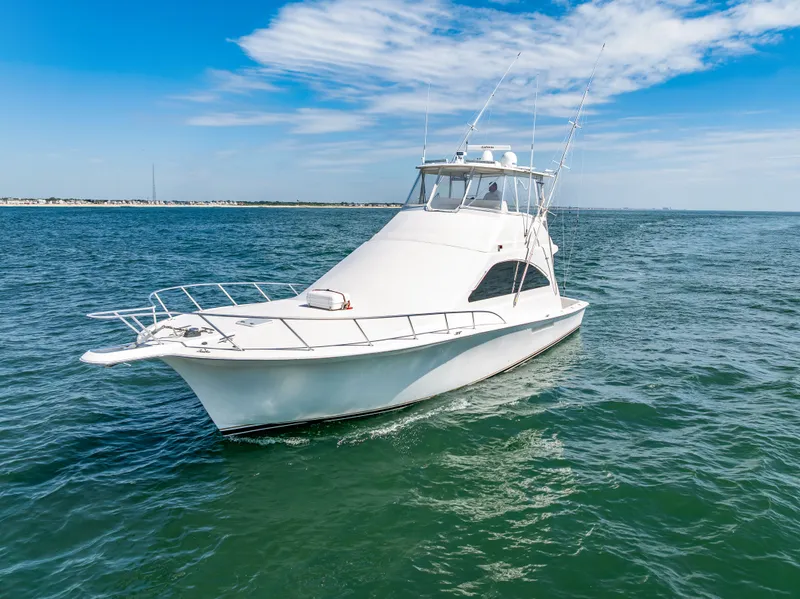 Slide: The Image of A white yacht cruises on calm water under a blue sky with some clouds. - 5