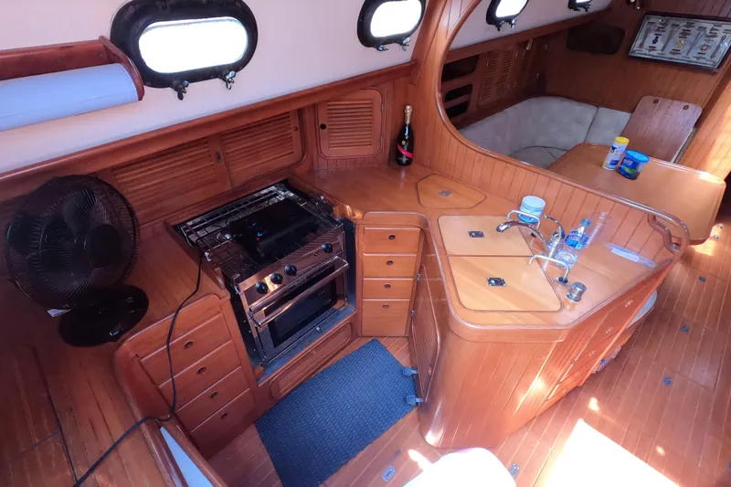 Slide: The Image of Interior of 1986 Ta Shing Baba 40 sailboat with wooden cabinetry and kitchen amenities. - 12