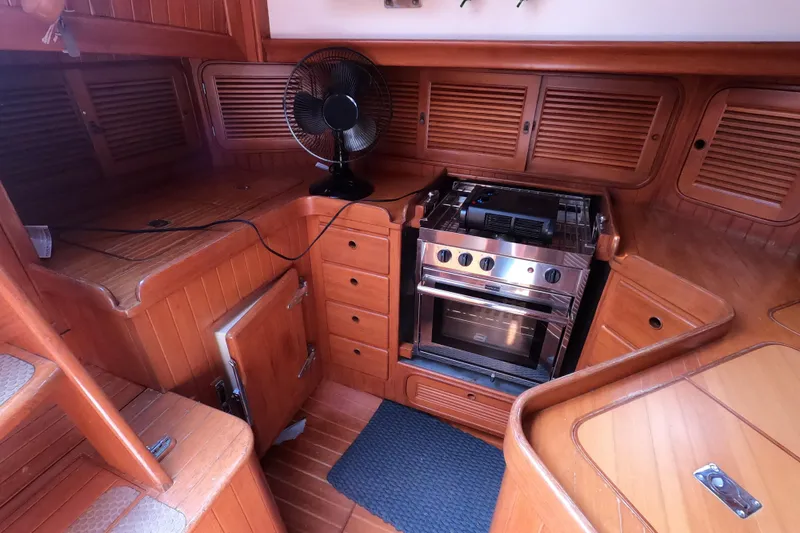 Slide: The Image of Interior of 1986 Ta Shing Baba 40 sailboat kitchen with wooden cabinetry and stove. - 13