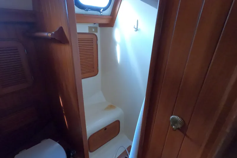 Slide: The Image of Interior of 1986 Ta Shing Baba 40 sailboat, featuring wooden cabinetry and compact bathroom. - 28
