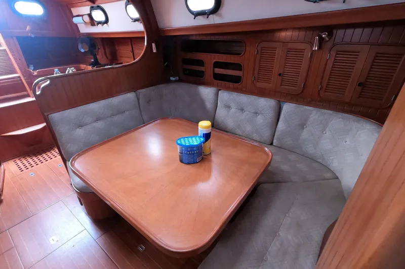 Slide: The Image of Interior of 1986 Ta Shing Baba 40 sailboat with wooden dining area and cushioned seating. - 31