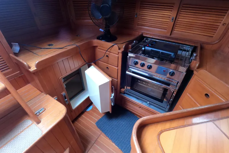 Slide: The Image of 1986 Ta Shing Baba 40 yacht interior with wooden cabinetry and stainless steel stove. - 38
