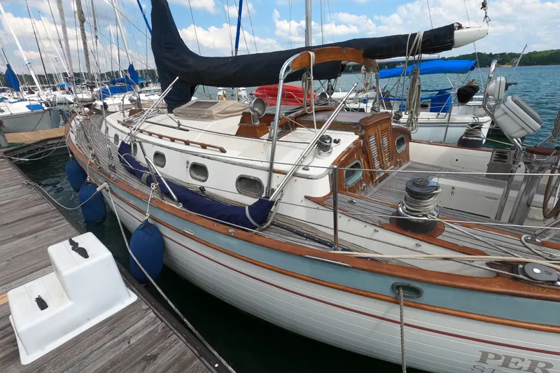 Slide: The Image of 1986 Ta Shing Baba 40 sailboat docked at marina, featuring classic wooden details. - 6