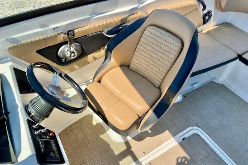 Slide: The Image of 2022 Sea Ray SPX 210 Outboard boat interior with steering wheel and beige seating. - 13