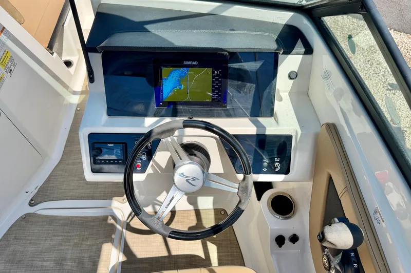 Slide: The Image of 2022 Sea Ray SPX 210 Outboard dashboard with steering wheel and navigation display. - 15