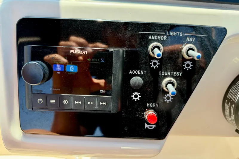 Slide: The Image of Control panel of 2022 Sea Ray SPX 210 Outboard with Fusion audio system and light switches. - 18
