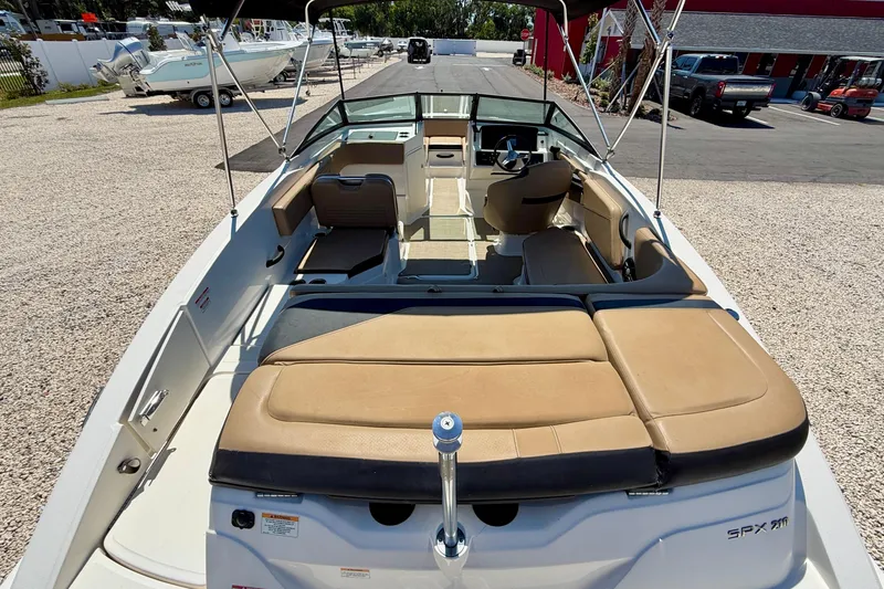 Slide: The Image of 2022 Sea Ray SPX 210 Outboard boat with tan seating, parked on gravel. - 21