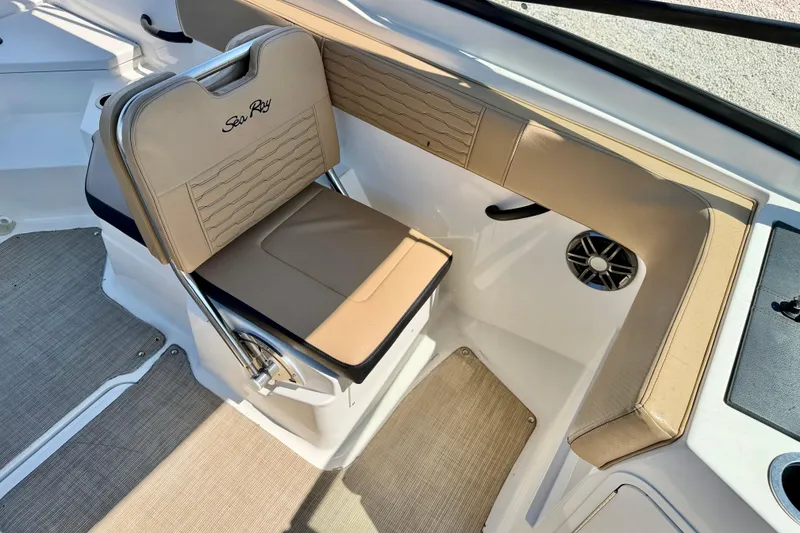 Slide: The Image of 2022 Sea Ray SPX 210 Outboard interior with beige seating and speaker detail. - 22
