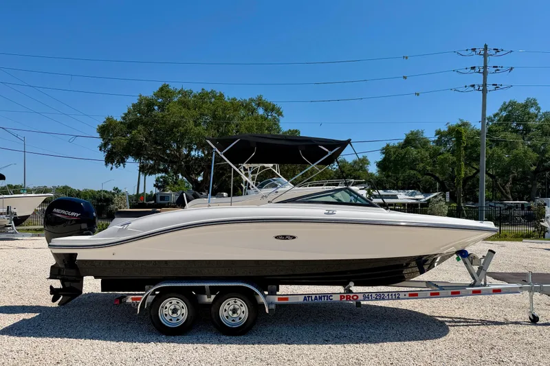 Slide: The Image of 2022 Sea Ray SPX 210 Outboard boat on trailer, parked outdoors under clear blue sky. - 4