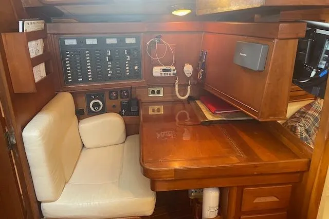 Slide: The Image of Navigation station in a 2001 Tartan 3700 sailboat with control panels and seating. - 13