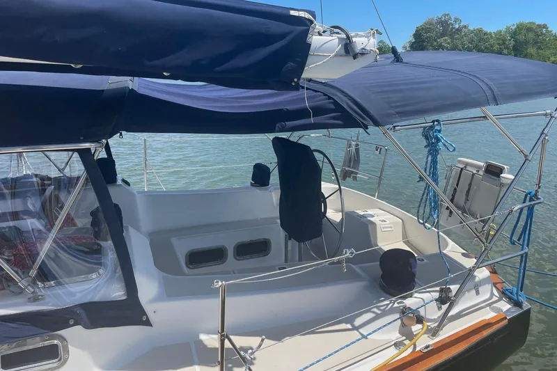 Slide: The Image of 2001 Tartan 3700 sailboat with blue canopy, docked on a sunny day. - 2