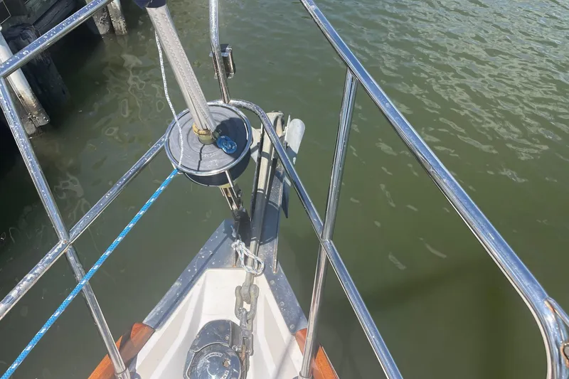 Slide: The Image of Bow of 2001 Tartan 3700 sailboat with stainless steel railing and anchor, docked on calm water. - 22