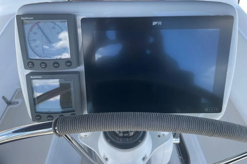 Slide: The Image of Cockpit instruments of a 2001 Tartan 3700 sailboat, featuring Raytheon displays and steering wheel. - 23