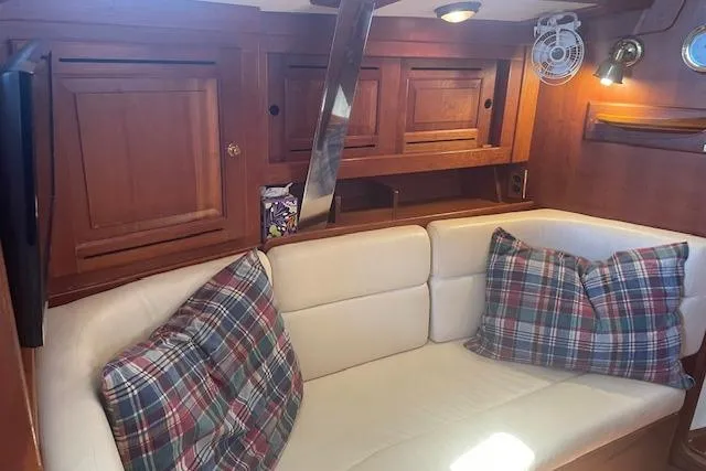Slide: The Image of Cozy interior of 2001 Tartan 3700 sailboat with plaid pillows and wooden cabinetry. - 7