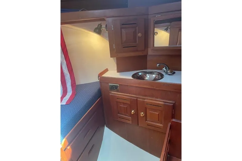 Slide: The Image of Interior of 2001 Tartan 3700 sailboat with wooden cabinetry and compact sink area. - 8