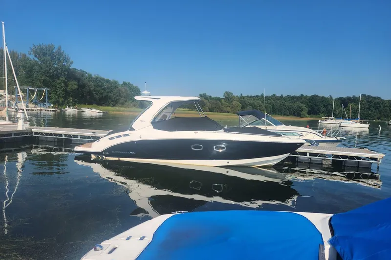 The Image of 2023 Chaparral 347 SSX boat docked on a serene lake under clear blue skies. - 0