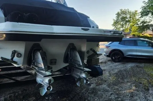 Slide: The Image of 2023 Chaparral 347 SSX boat with dual propellers, parked near a modern SUV. - 15