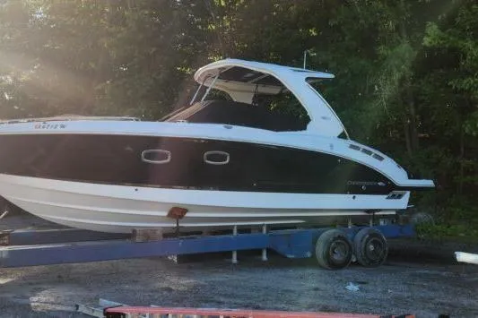 Slide: The Image of 2023 Chaparral 347 SSX boat on trailer, parked outdoors with trees in the background. - 17