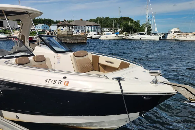 Slide: The Image of 2023 Chaparral 347 SSX boat docked in a marina with other vessels. - 2