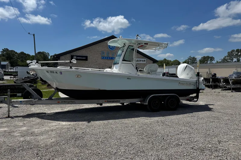 The Image of 2020 Everglades 253 Center Console boat on trailer at dealership under clear sky. - 0