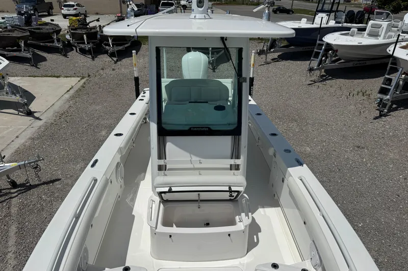 Slide: The Image of 2020 Everglades 253 Center Console boat, docked with visible seating and storage. - 2