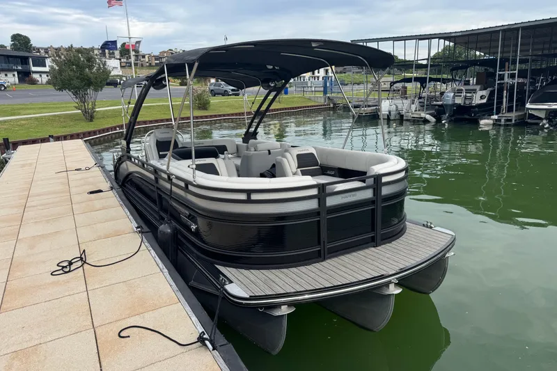 Slide: The Image of 2023 Harris Solstice 230 pontoon boat docked at a marina. - 3