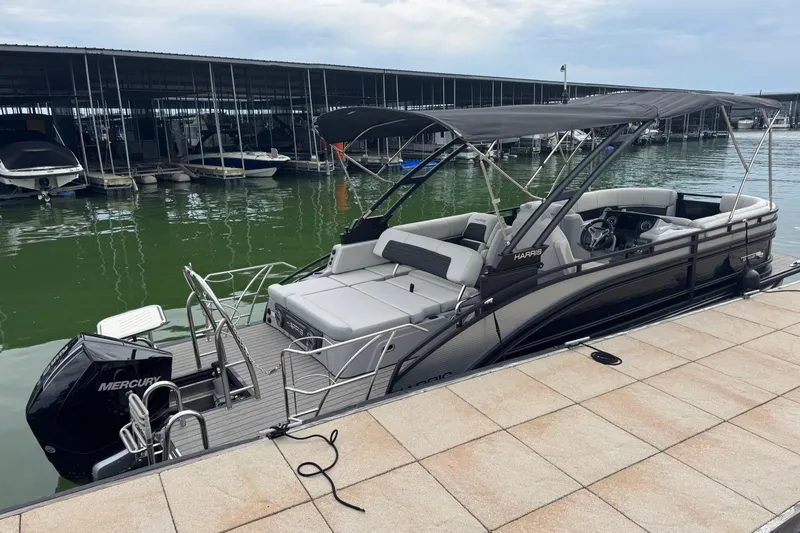 Slide: The Image of 2023 Harris Solstice 230 pontoon boat docked at marina with Mercury engine. - 5