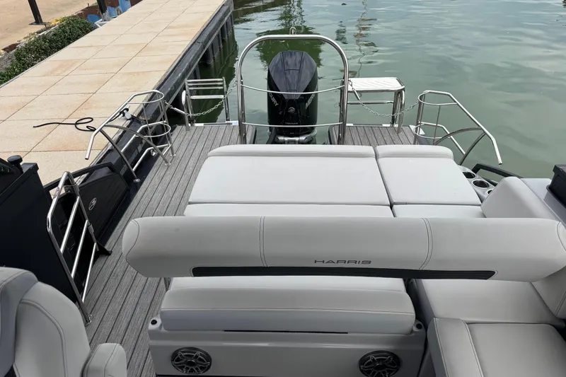Slide: The Image of 2023 Harris Solstice 230 boat interior with plush seating and sleek design at dockside. - 8