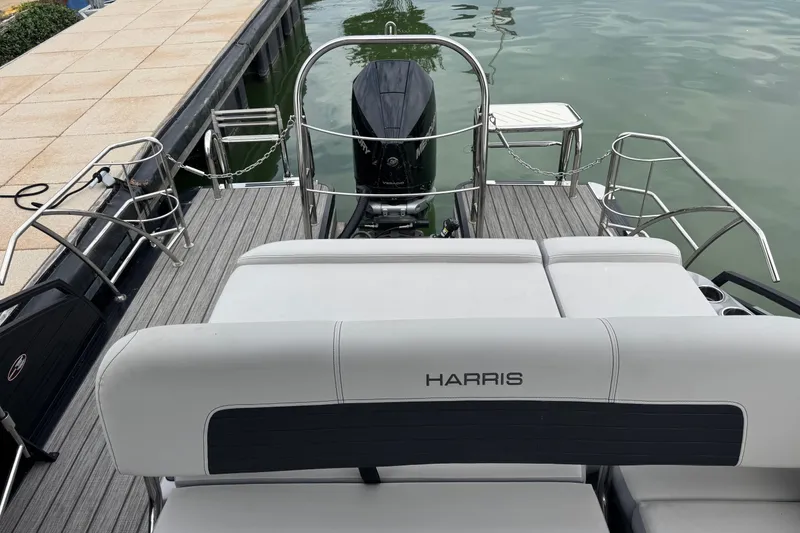 Slide: The Image of 2023 Harris Solstice 230 pontoon boat with sleek seating and modern design at dock. - 9