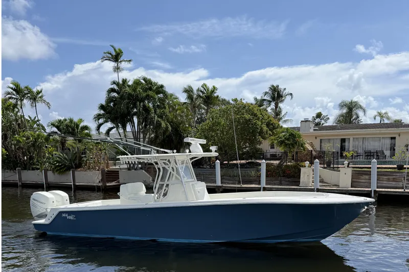 The Image of 2018 SeaVee 340Z boat docked by waterfront home, surrounded by palm trees. - 1