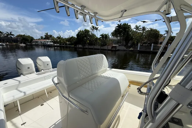 Slide: The Image of 2018 SeaVee 340Z boat interior with dual Mercury engines, docked by a scenic waterfront. - 14