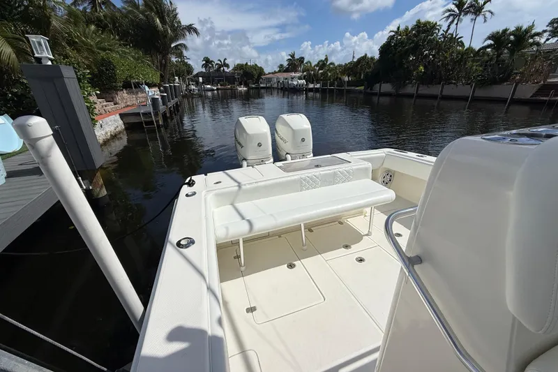 Slide: The Image of 2018 SeaVee 340Z boat docked, featuring dual outboard engines and spacious seating area. - 16