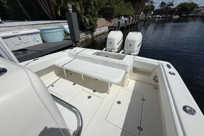 Slide: The Image of 2018 SeaVee 340Z boat with spacious deck and twin Mercury outboard engines docked by the water. - 17