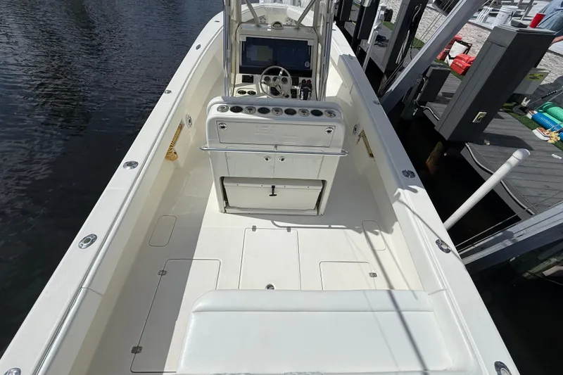 Slide: The Image of 2018 SeaVee 340Z boat interior with helm, seating, and storage, docked by the water. - 19