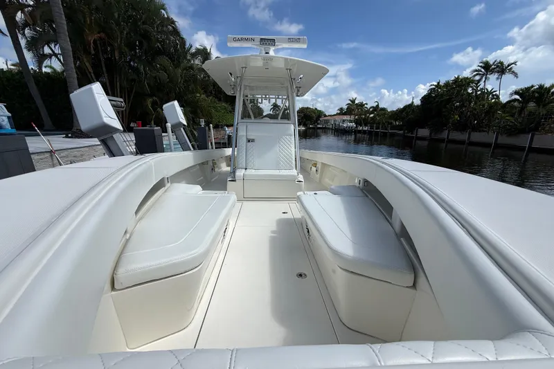 Slide: The Image of 2018 SeaVee 340Z boat interior with white seating, docked by a canal. - 5