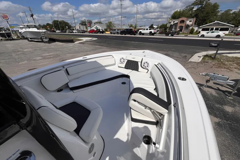 Slide: The Image of 2026 Tidewater 210 LXF boat interior with seating and speakers, parked near a road. - 12