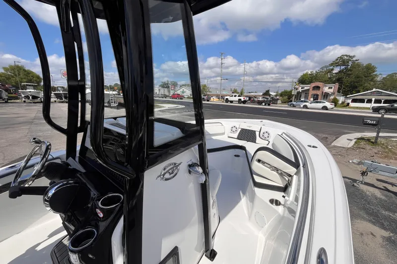 Slide: The Image of 2026 Tidewater 210 LXF boat interior with steering console and seating, parked outdoors. - 13