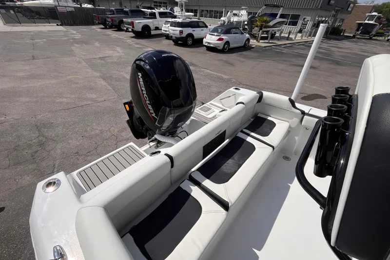 Slide: The Image of 2026 Tidewater 210 LXF boat with Mercury engine, docked in a marina parking area. - 15