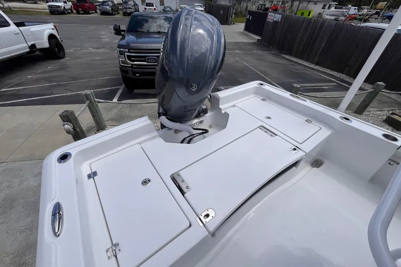 Slide: The Image of 2026 Tidewater 2210 Carolina Bay boat with outboard motor in a parking area. - 13