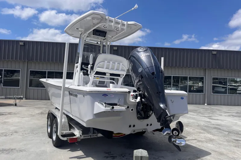 Slide: The Image of 2026 Tidewater 2210 Carolina Bay boat with powerful outboard motor, parked outdoors. - 3