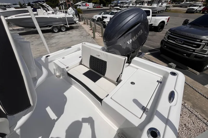 Slide: The Image of 2026 Tidewater 2210 Carolina Bay boat with Yamaha engine, parked near trucks and trailers. - 4
