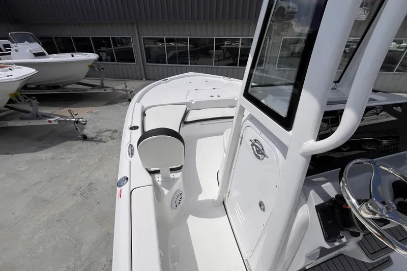 Slide: The Image of 2026 Tidewater 2210 Carolina Bay boat interior with seating and console, displayed outdoors. - 7