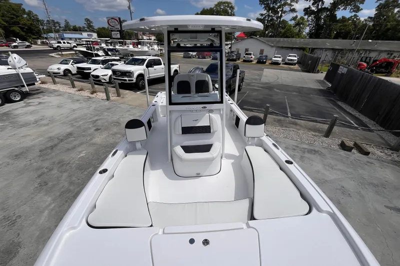 Slide: The Image of 2026 Tidewater 2210 Carolina Bay boat displayed at a dealership with parked vehicles. - 9