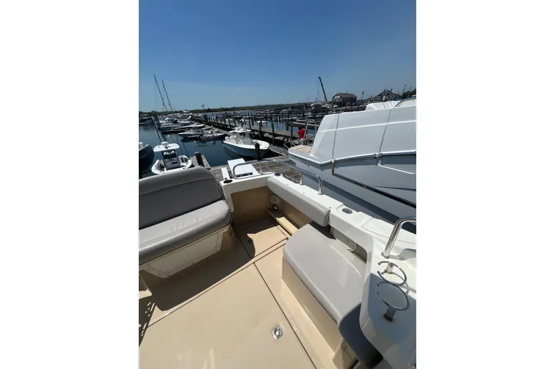 Slide: The Image of 2012 Cutwater 26 boat interior with seating, docked at marina under clear blue sky. - 3