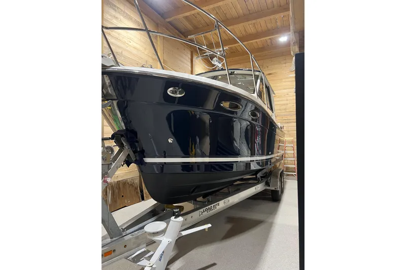 Slide: The Image of 2012 Cutwater 26 boat on trailer in wooden garage. - 1