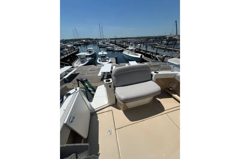 Slide: The Image of 2012 Cutwater 26 boat docked at a marina with seating area. - 2