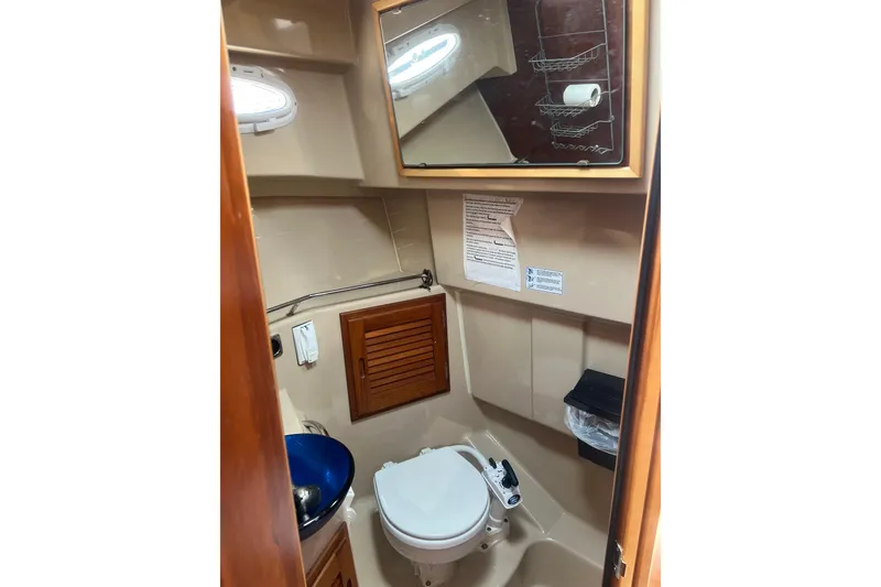 Slide: The Image of 2012 Cutwater 26 boat bathroom with toilet, sink, mirror, and storage cabinet. - 10