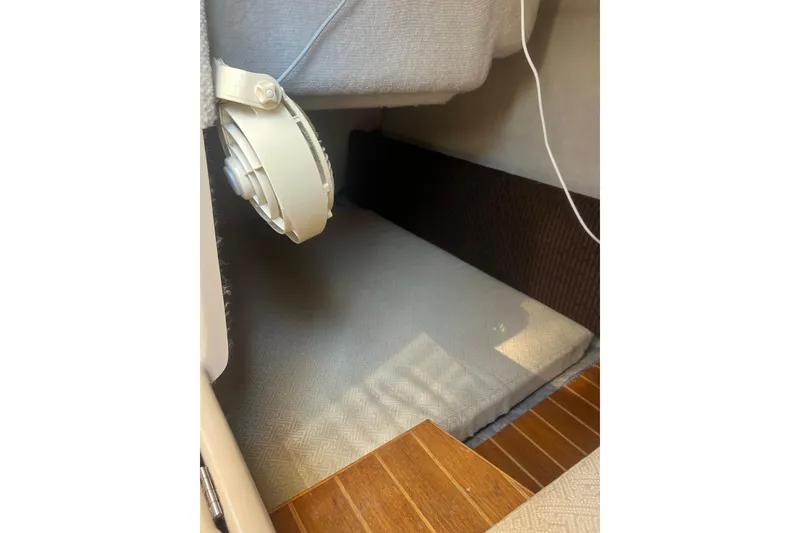 Slide: The Image of Interior cabin space of a 2012 Cutwater 26 boat, featuring a fan and cushioned area. - 11